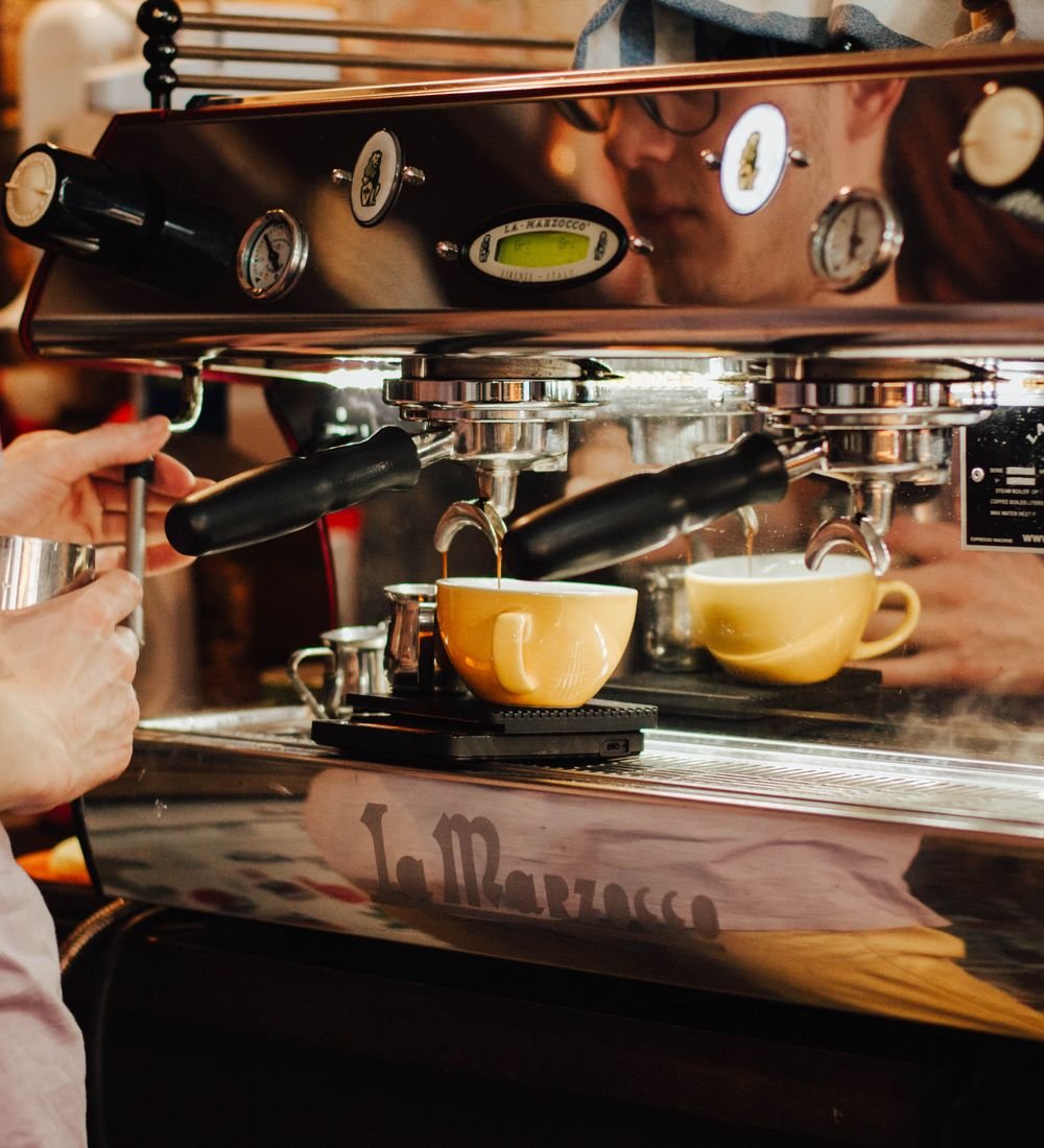 Espresso pouring into yellow cups on the café espresso machine