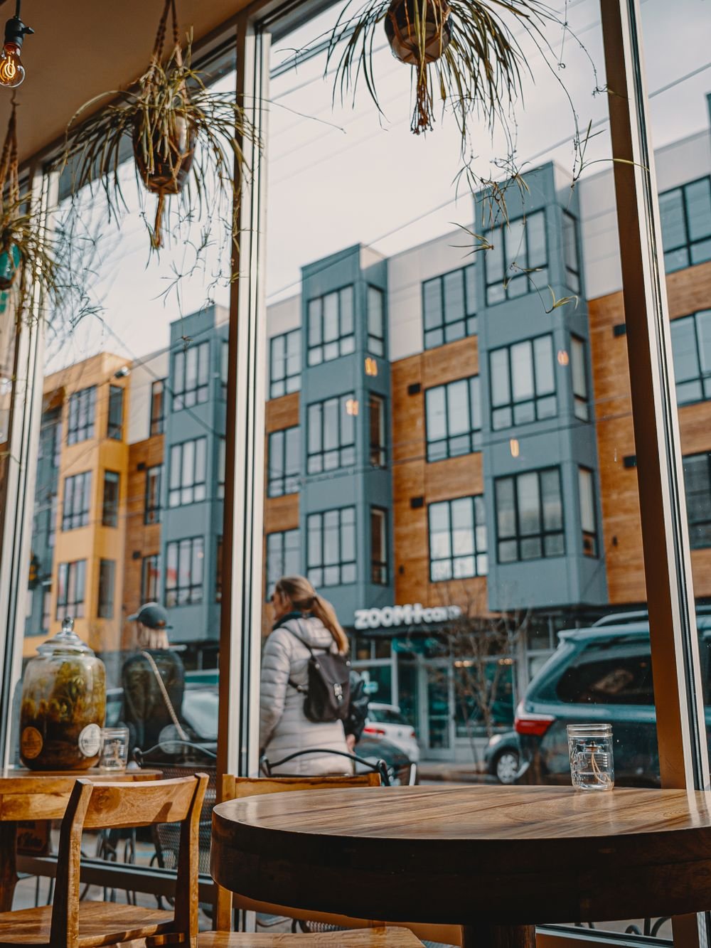 Wooden café tables by the front window, with the street beyond